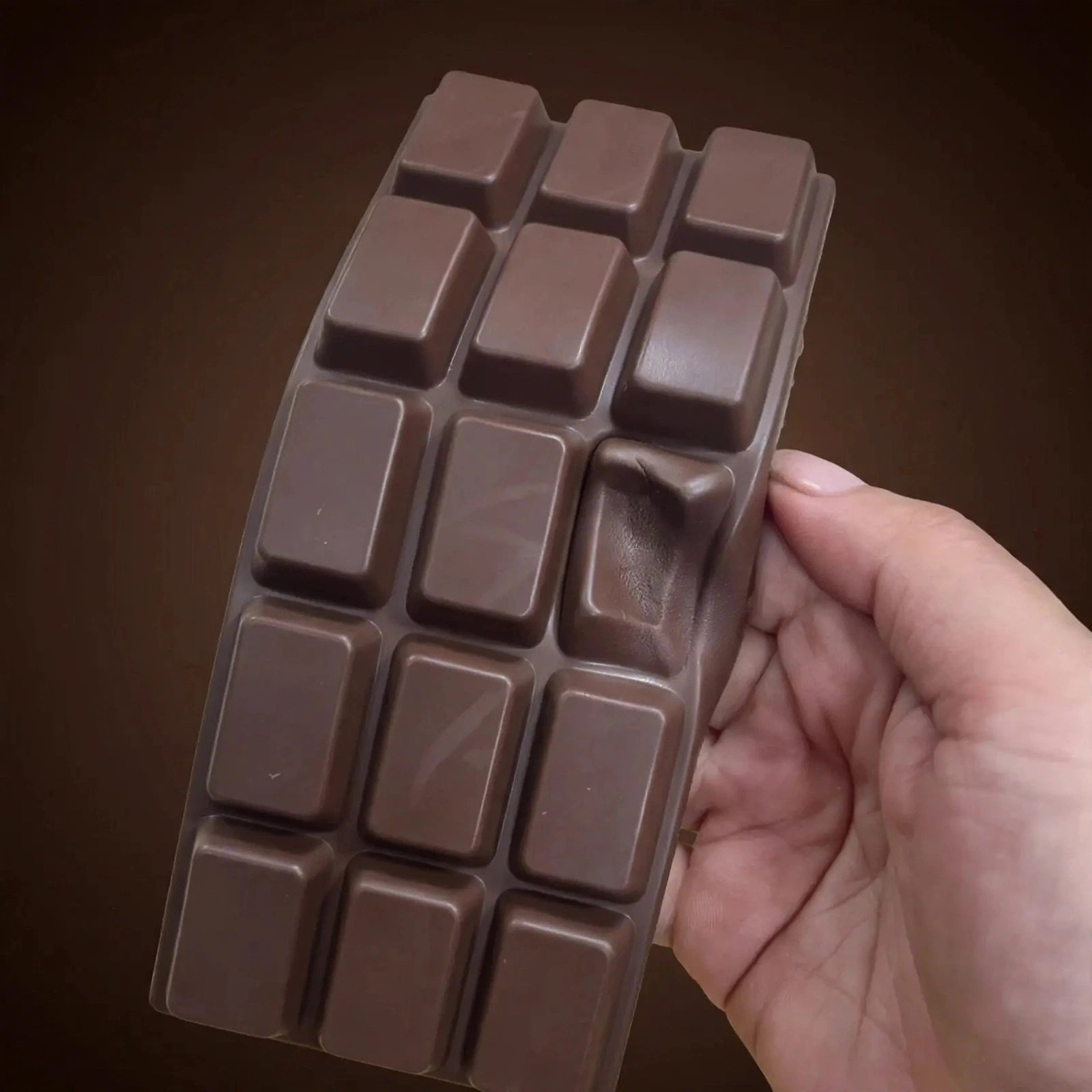 Hand squeezing the Chocolate bar squishy soft foam