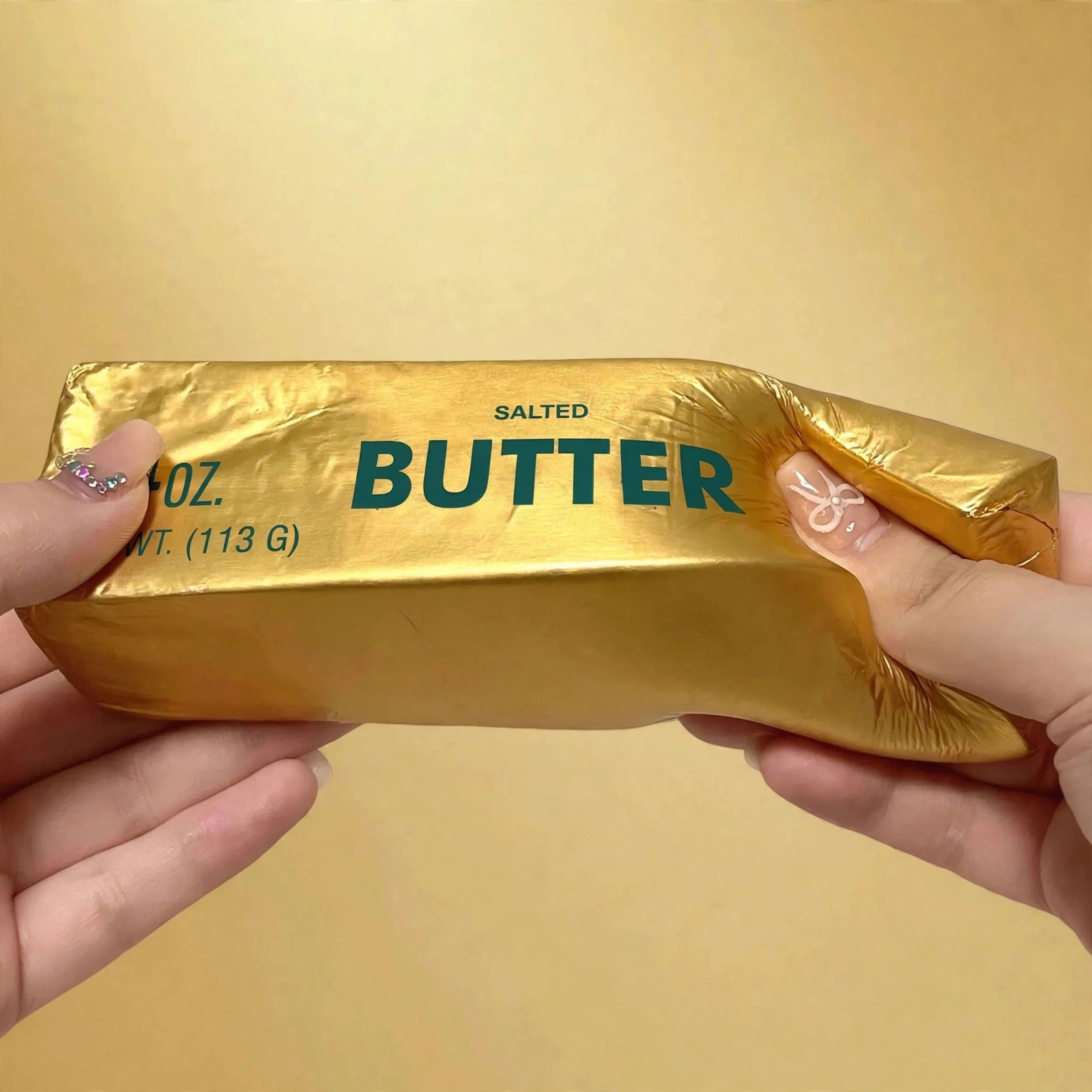 Hands bending the golden butter squishy showing its soft foam