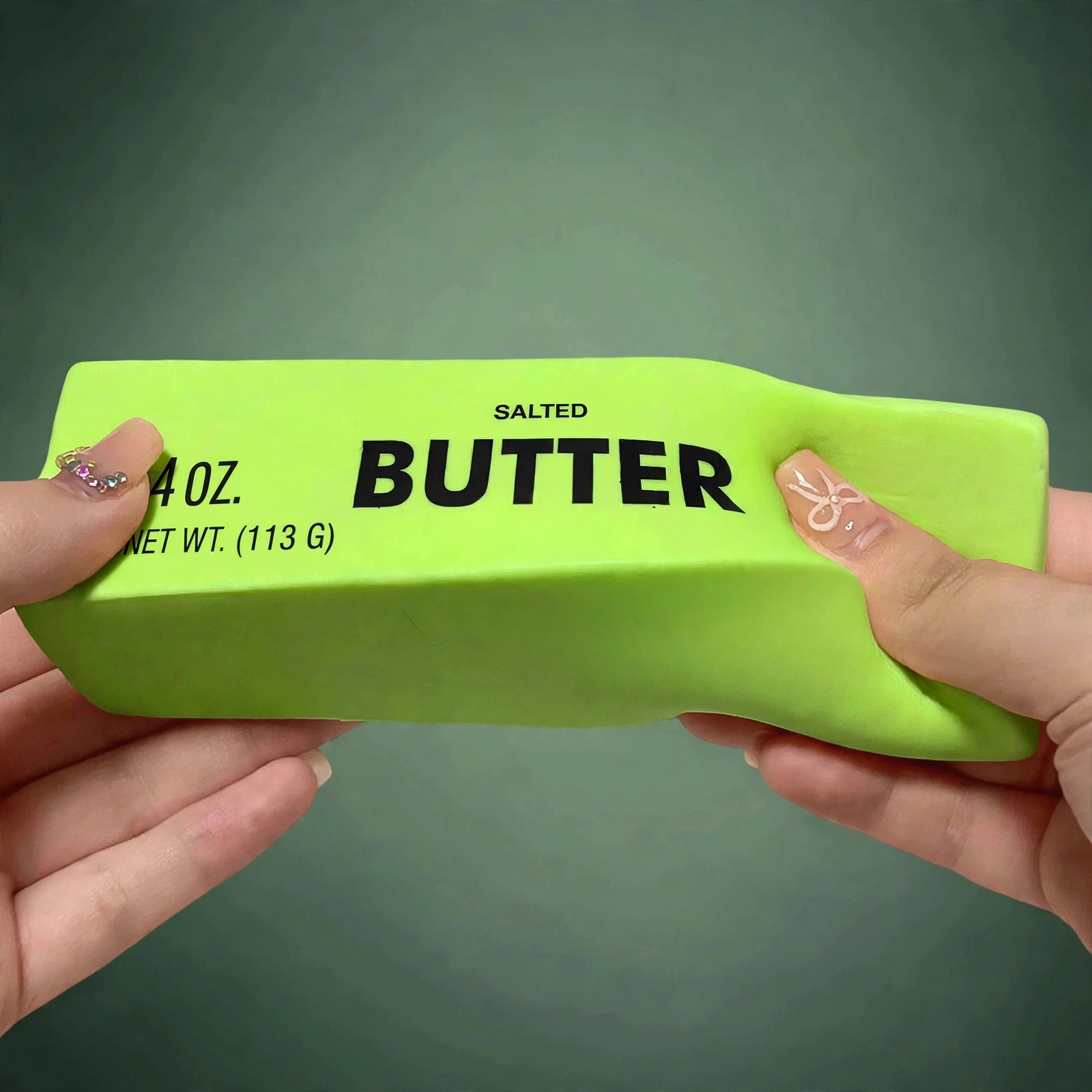 Hands squeezing the green butter squishy soft foam